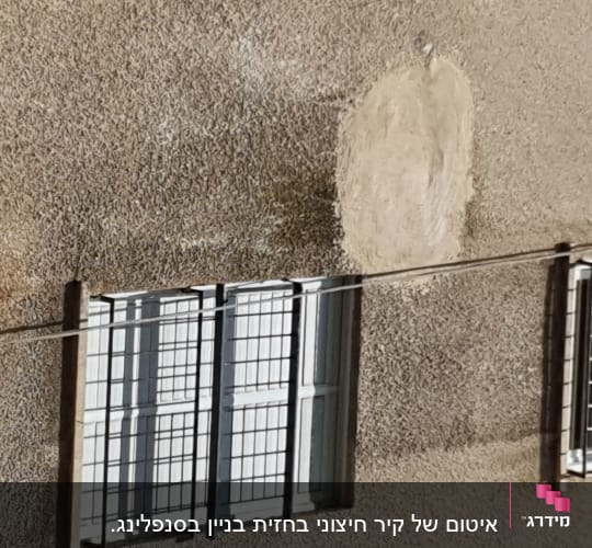 קיר בניין עם חלון וסורגים
